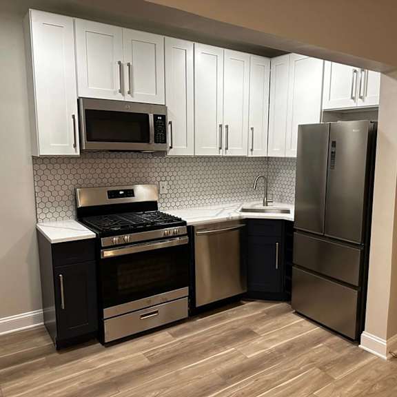 a kitchen with appliances and white cabinets at evelyn apartments, oak park, il