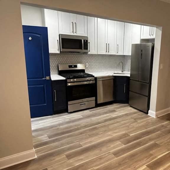 a kitchen with a blue door and a stove top oven at evelyn apartments, oak park, illinois