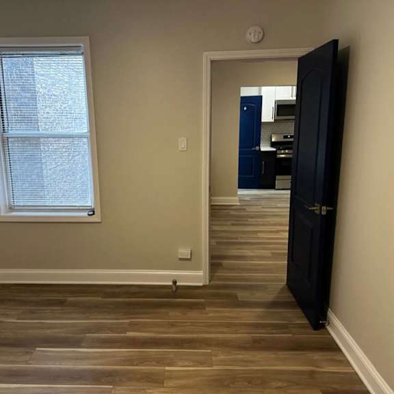 bedroom with a wooden floor and a black door at evelyn apartments, oak park, 60304