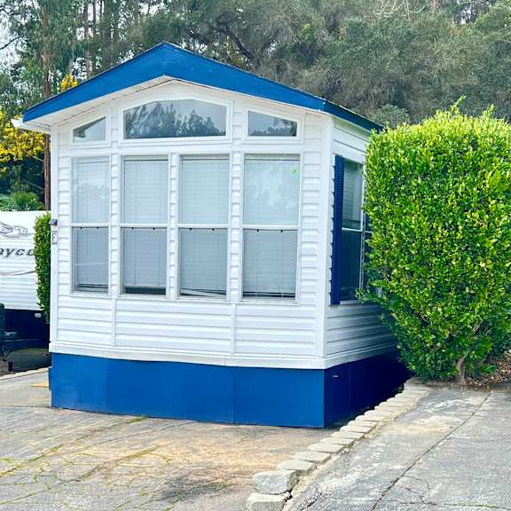 a white and blue house with a grey roof.