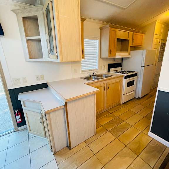 a kitchen with wooden cabinets and a white counter.