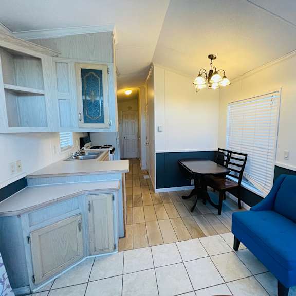a kitchen with a blue chair and a table.