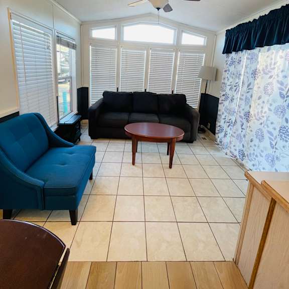 a living room with a blue couch, a black couch, and a brown coffee table.