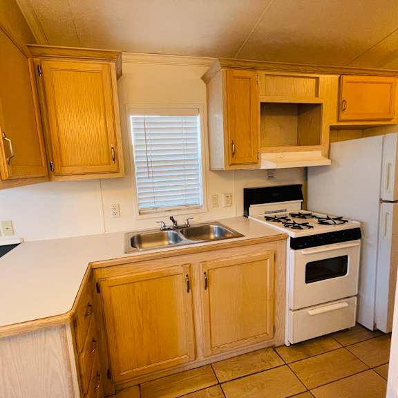 a kitchen with wooden cabinets and a white refrigerator.