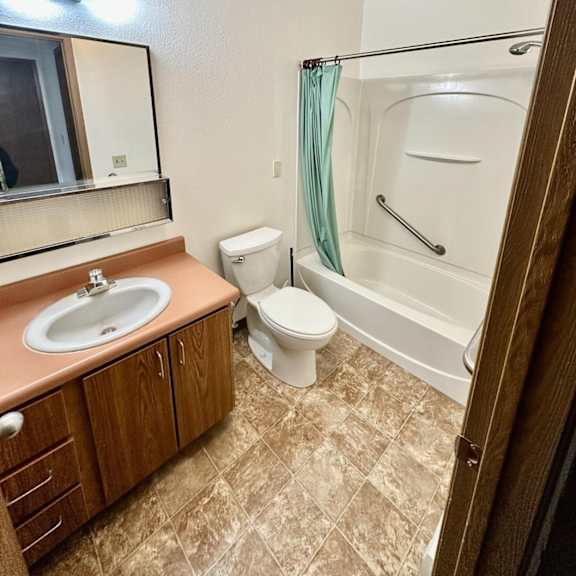a bathroom with a toilet, sink, and bathtub.