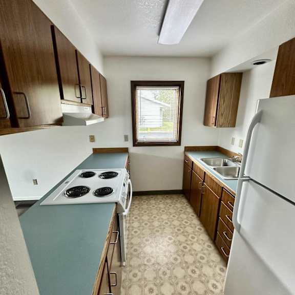 a kitchen with a white fridge and a white stove top.