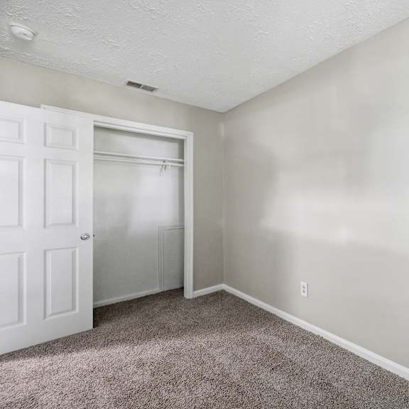 a room with a white door and carpeted floor.