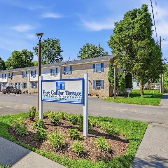 a sign for fort collier terrace stands in front of a building.