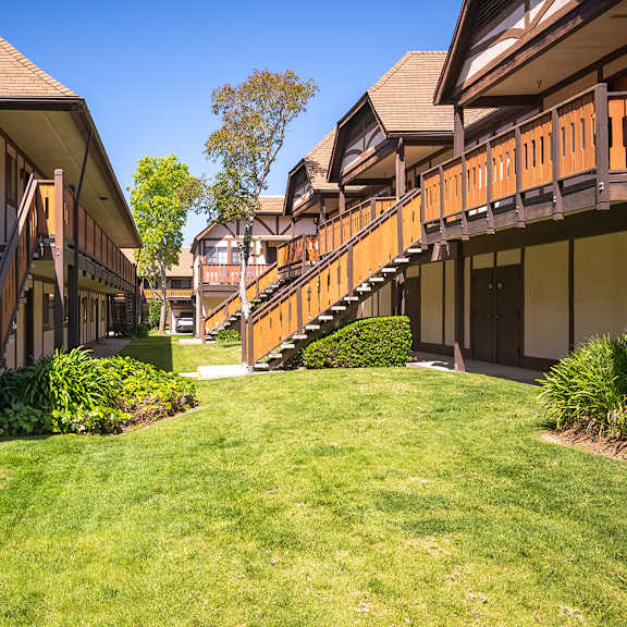 apartment building with stairs and a grass yard at oak park apartments, solvang, california