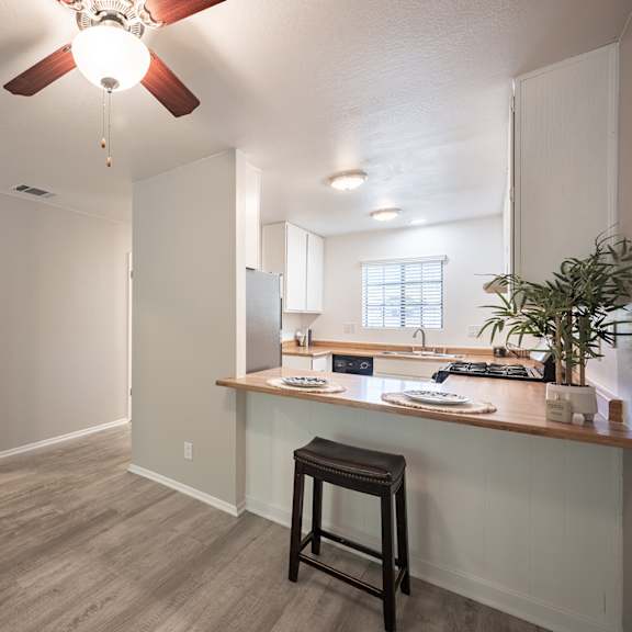 kitchen and living room with a ceiling fan at oak park apartments, solvang, 93463
