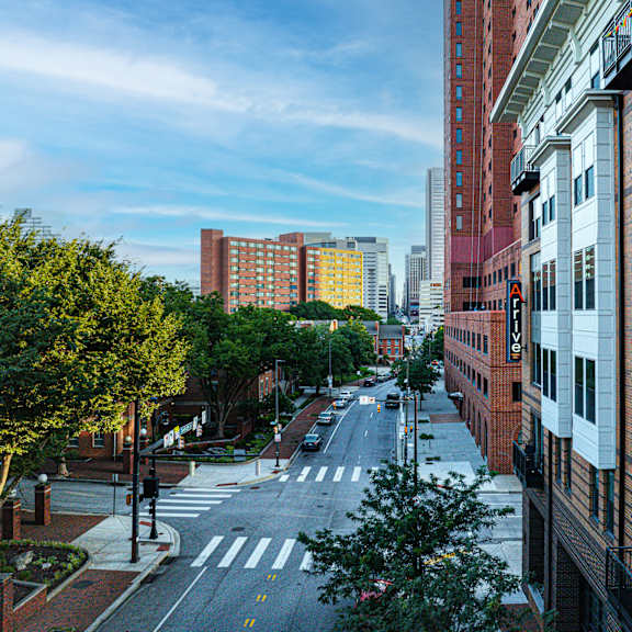 a city street with buildings on both sides and a crosswalk in the middle.
