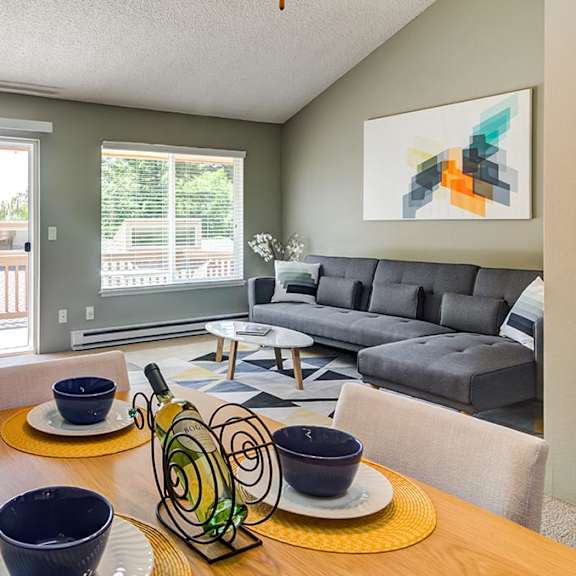 a living room with a table and chairs with a couch in the background at the bluffs at mountain park, oregon, 97035