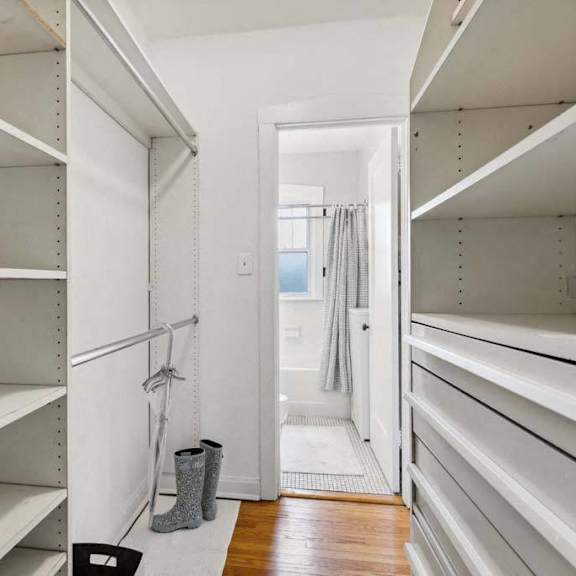 a large walk in closet with white shelves and a door at the bryant at oak park i & ii, oak park, 60302