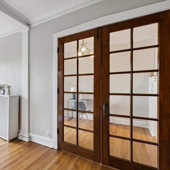 a living room with a wooden door and a window at the bryant at oak park i & ii, oak park, il 60302