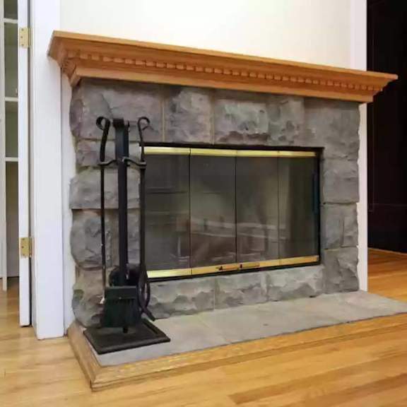 a stone fireplace in a living room with a wood floor at the bryant at oak park i & ii, oak park, il 60302