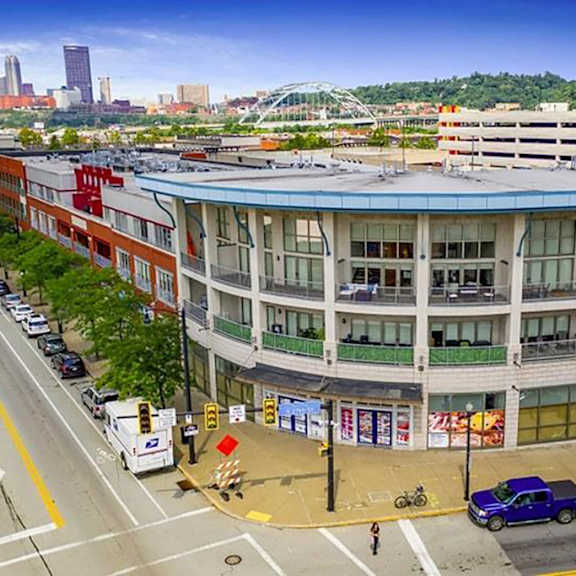 a large building with a blue roof on a city street at flats at southside, pittsburgh pennsylvania