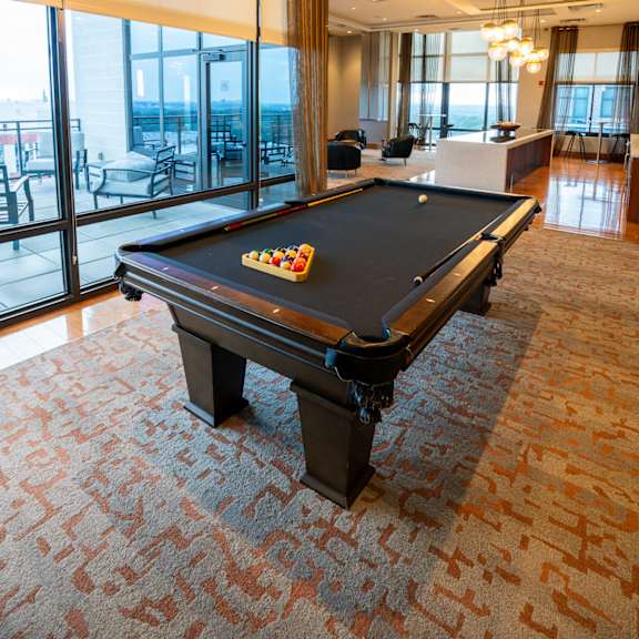 a pool table in a room with a view of the outside.