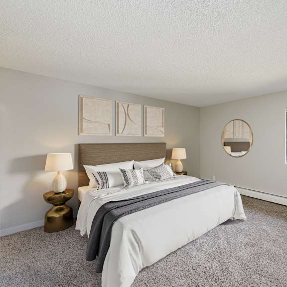 a bedroom with a large bed, two lamps, and a potted plant.
