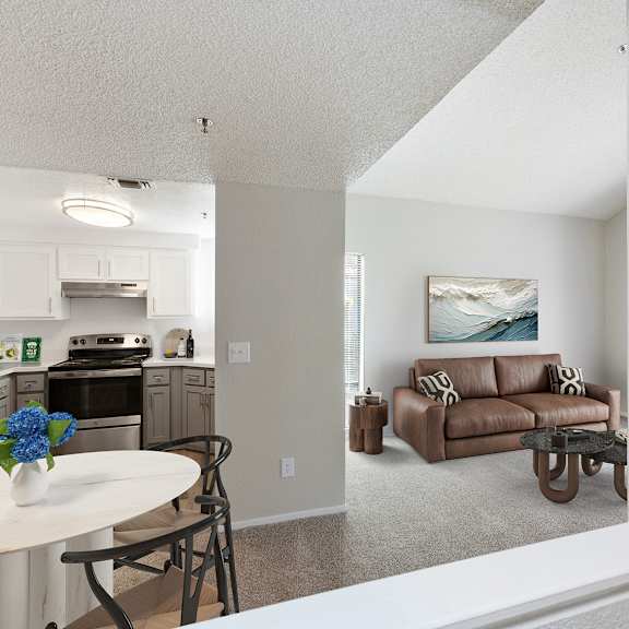 a kitchen with a table and chairs and a couch in the living room.