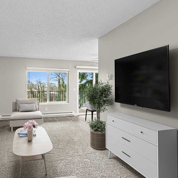 a living room with a grey couch, a white coffee table, and a flat screen tv mounted on the wall.