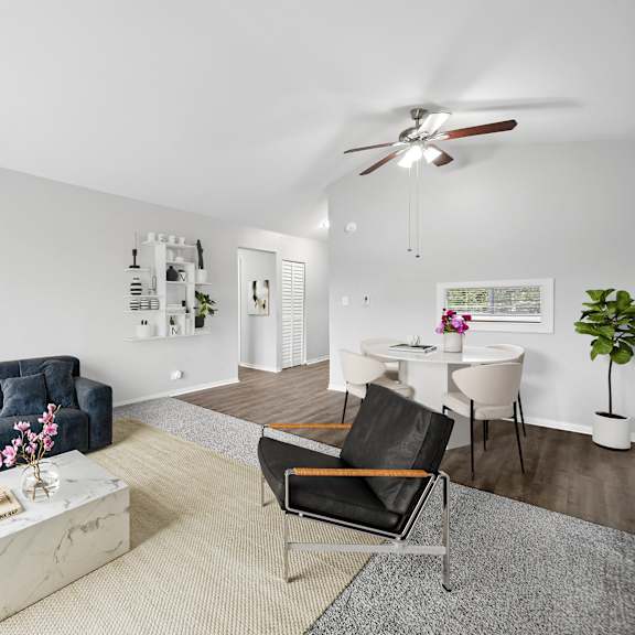 a living room with a blue couch, a white coffee table, and a ceiling fan.