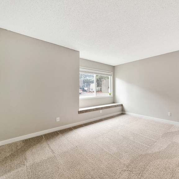 a room with a carpeted floor and a window with blinds. at river lofts apartments, tualatin, or, 97062