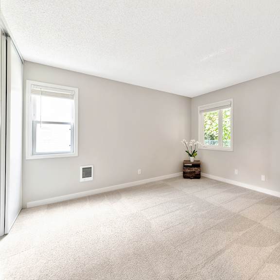a room with a carpeted floor and two windows. at river lofts apartments, tualatin, or