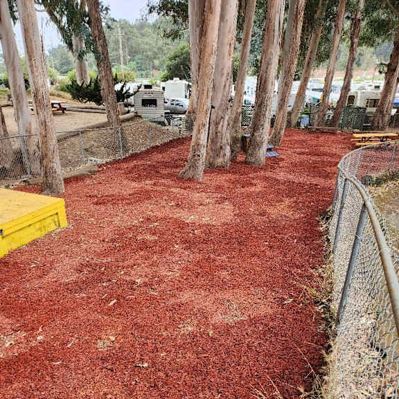 a red mulched area with a fence on the right side at salinas sunset apartments, salinas, ca, 93907