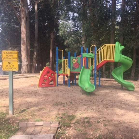 a playground with a green slide and a red and yellow structure at salinas sunset apartments, salinas, 93907