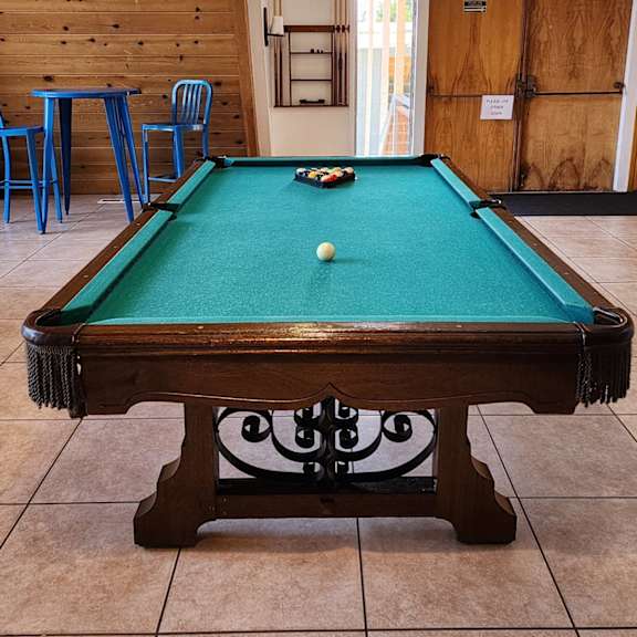 a pool table with a green cloth and a white ball in the middle. at salinas sunset apartments, salinas, ca
