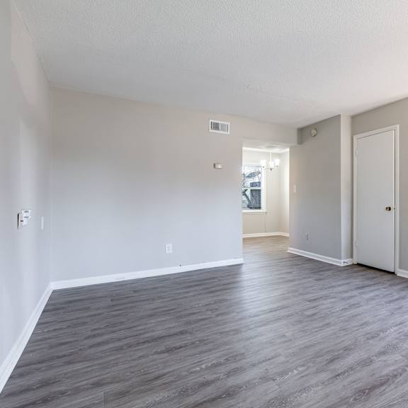 an empty living room with stairs and a door to a hallway at sharon west, charlotte north carolina