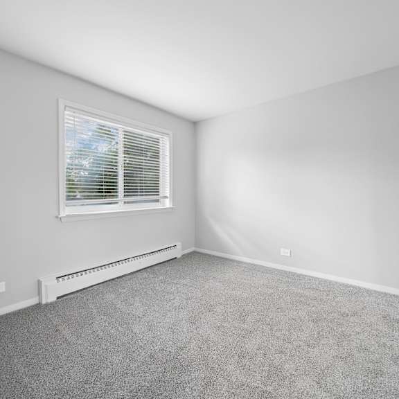 a room with a window and a radiator on the wall.
