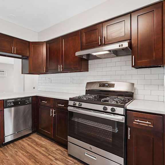 a kitchen with brown cabinets and a stainless steel oven.