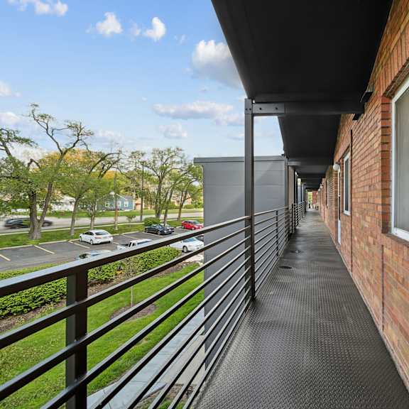 a balcony with a black railing and a brick wall.