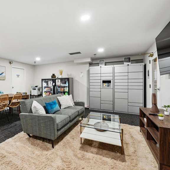 a living room with a grey couch, a wooden table, and a rug.
