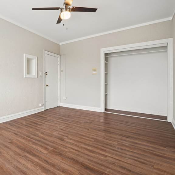 a room with a ceiling fan and a sliding door.