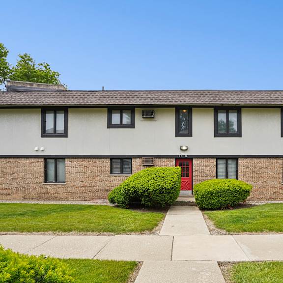 a house with a red door and a brick facade.