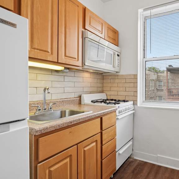 a kitchen with wooden cabinets and white appliances.