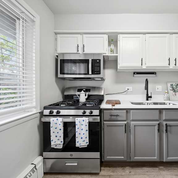 a kitchen with a stove, microwave, and cabinets.