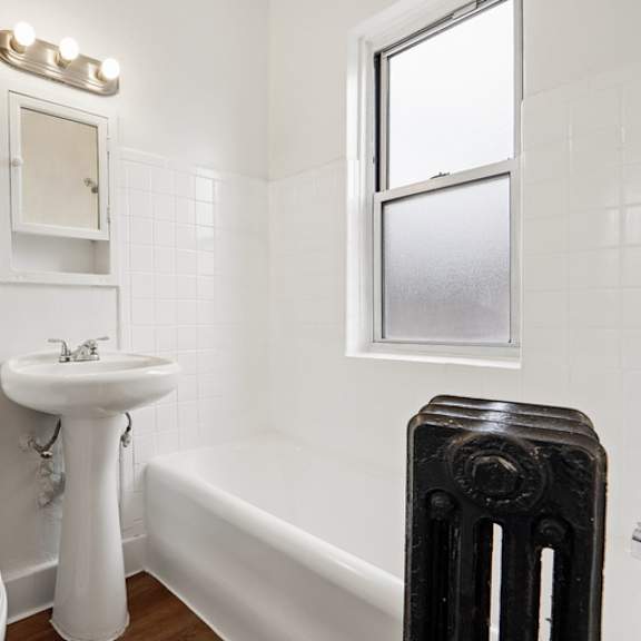 a white toilet sits next to a white sink in a small bathroom.