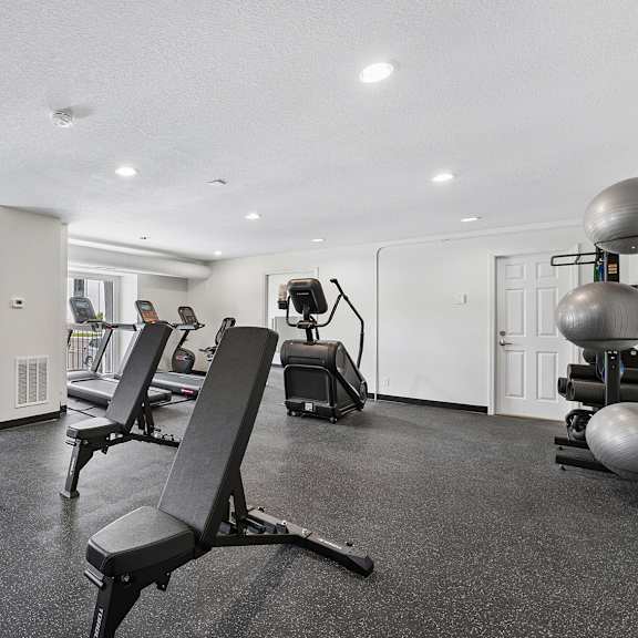 fitness center with a variety of equipment including weights and exercise machines.