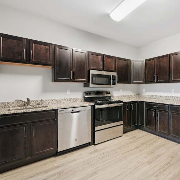 a kitchen with dark brown cabinets and stainless steel appliances.
