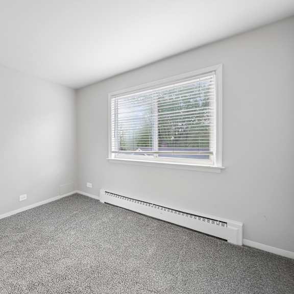 a room with a window and a radiator on the wall.