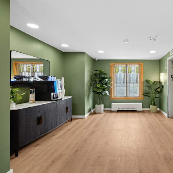 a hallway with a green wall and a wooden floor.