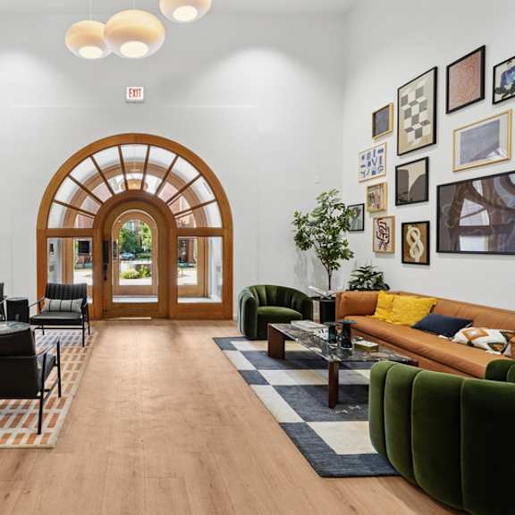 a living room with a wooden floor and a large arched doorway.