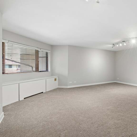a spacious room with a staircase on the right side.