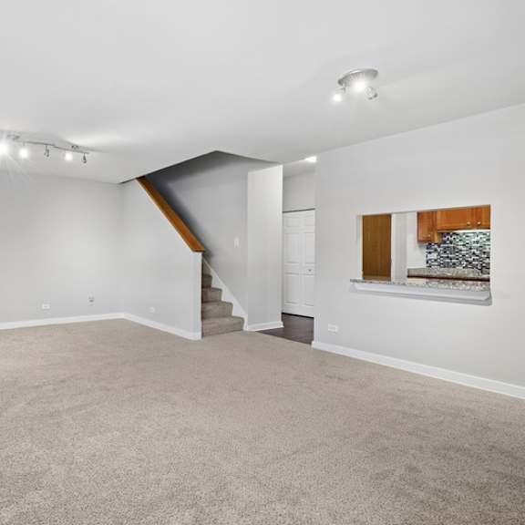 a spacious room with a staircase leading to another level.