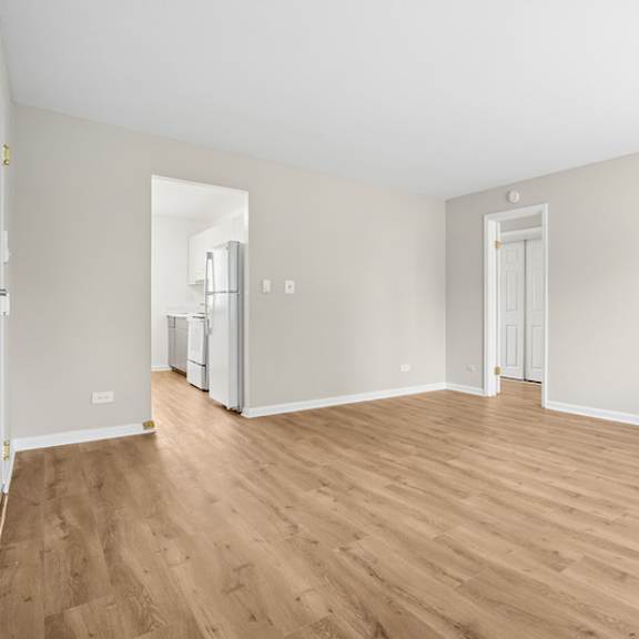 a room with wooden flooring and white walls.