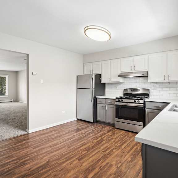 a kitchen with white cabinets and a stainless steel oven.