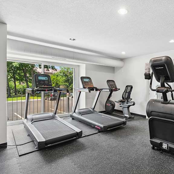 fitness room with a treadmill, elliptical trainer, and a stationary bike.